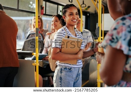 African american female student traveling by public bus and holding books
