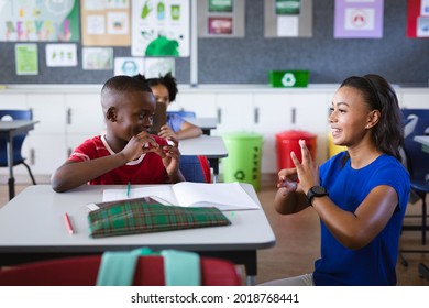 African american female teacher and boy talking in hand sign language at elementary school. school and education concept - Powered by Shutterstock