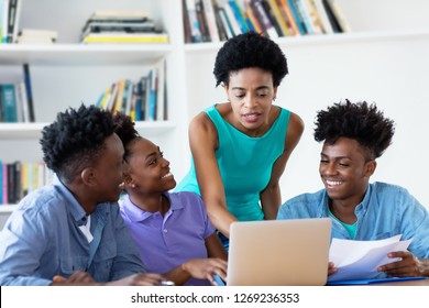 African American Female Teacher With Students At University