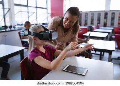 African american female teacher teaching caucasian girl to use vr headset in the class at school. school and education concept - Powered by Shutterstock