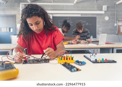 African American female teenager Student working on electronics robotics in the technology course - Powered by Shutterstock