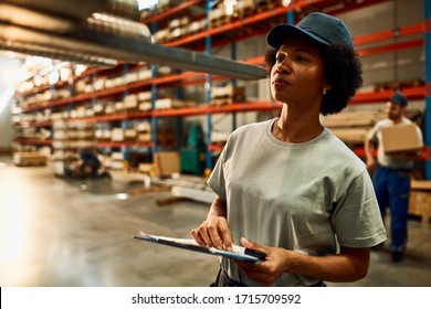 African American Female Worker Inspecting Steel Products While Working In A Warehouse. 