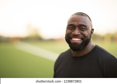 African American Football Coach Smiling Standing On A Field.