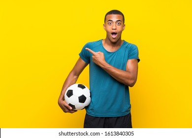 African American football player man surprised and pointing side - Powered by Shutterstock