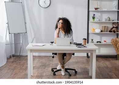 african american freelancer in glasses looking away while working from home - Shutterstock ID 1904135914