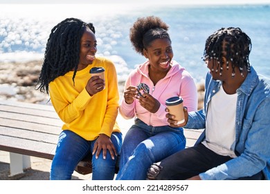 African american friends having breakfast sitting on bench at seaside - Powered by Shutterstock