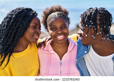 African American Friends Hugging Each Other Sitting On Bench Together At Seaside