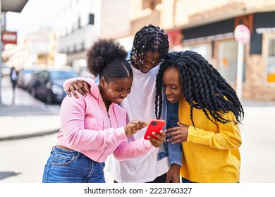African american friends standing together using smartphone at street - Powered by Shutterstock