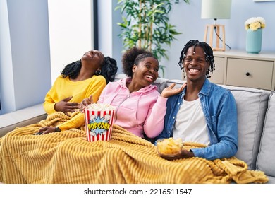 African american friends watching movie sitting on sofa at home - Powered by Shutterstock