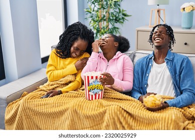 African american friends watching movie sitting on sofa at home - Powered by Shutterstock