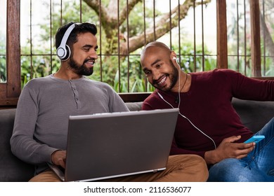 African American Gay Couple Looking At Laptop Screen At Home