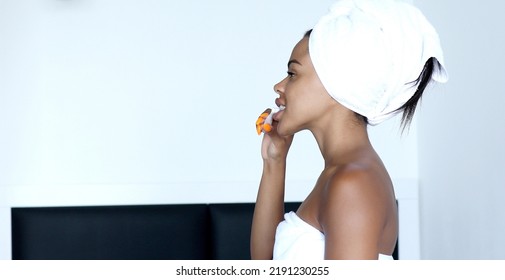 African American Girl Brushing Teeth With Toothbrush Looking In Mirror In Bathroom. Dental Care Concept.