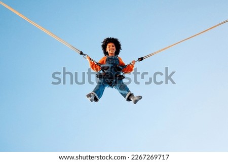 Similar – Image, Stock Photo Bungee jumping at trampoline. Little girl bouncing on bungee jumping in amusement park on summer vacations