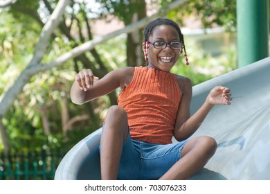 African American Girl On A Slide At A Playground