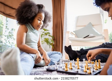 African American Girl Playing Chess With The African American Boy In The Living Room At Home