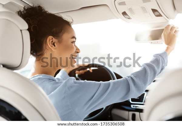 African American Girl\
Testing Car Adjusting Mirrors Sitting In Driver\'s Seat In\
Automobile. Selective\
Focus