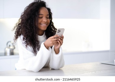 African American Girl using iPhone 12 smartphone pressing finger, reading social media internet, typing text or shopping online Mobile phone in two black hands 13.12.21 St.Petersburg Russia.