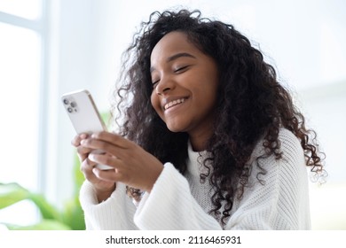 African American Girl using iPhone 12 smartphone pressing finger, reading social media internet, typing text or shopping online Mobile phone in two black hands 13.12.21 St.Petersburg Russia.