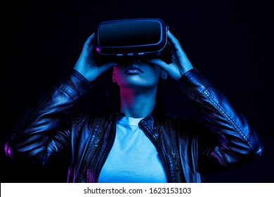 African american girl in vr glasses, watching 360 degree video with virtual reality headset isolated on black background, illuminated by neon lights - Powered by Shutterstock