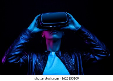 African american girl in vr glasses, watching 360 degree video with virtual reality headset isolated on black background, illuminated by neon lights - Powered by Shutterstock