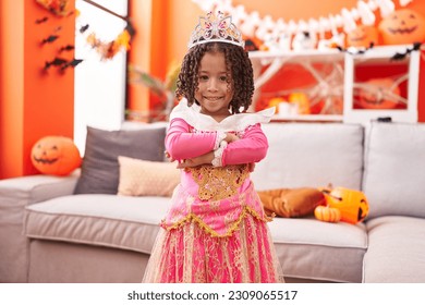 African american girl wearing princess costume standing with arms crossed gesture at home