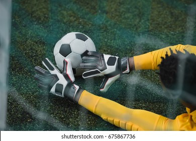 African American Goalkeeper Catching Soccer Ball During Game