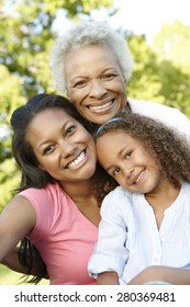 African American Grandmother, Mother And Daughter Relaxing In Park