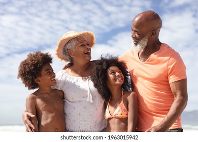 African American Grandparents And Grandchildren Smiling At The Beach. Travel Vacation Summer Beach Holiday Concept