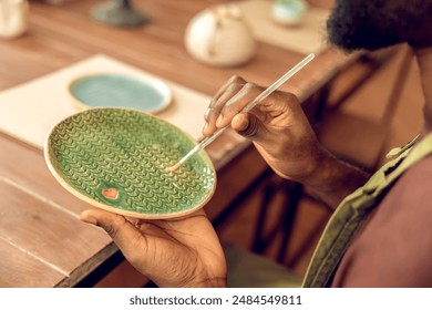 African american guy working with pottery in his workshop - Powered by Shutterstock