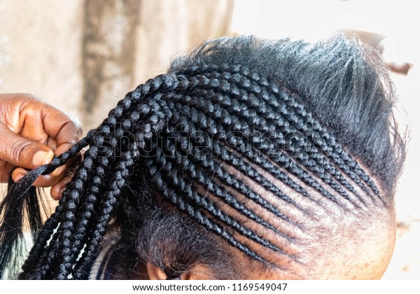 African American Hairdresser coiffeur weaves\
French braided, bride\'s hairstyle. Professional hair stylist makes\
black bride a wedding hairstyle for beauty salon and Professional\
hair care concept