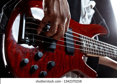 African American handsome jazz musician playing bass guitar in the studio on a black background. Music concept. Young joyful attractive guy improvising. Close-up retro portrait. - Powered by Shutterstock