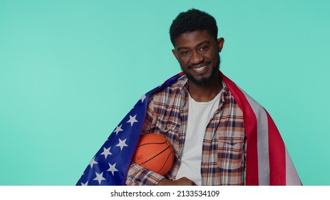 African American Happy Young Man 20s Sportsman Basketball Fan In Checkered Shirt Holding American USA Flag Doing Winner Gesture, Dancing Isolated On Blue Background. Workout Sport Motivation Lifestyle