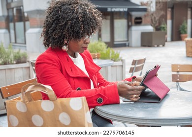 An african american Happy young woman in glasses reading e-book, shopping online - Shutterstock ID 2279706145