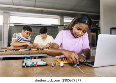 African American High School teenage Student programming electronics circuit board in the science technology workshop - Learning Digital Innovation in Education - Powered by Shutterstock