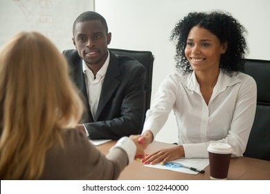 African american hr team welcoming female applicant at job interview, diverse businesswomen shaking hands at multi ethnic group meeting, handshaking and good first impression, teamwork introduction
