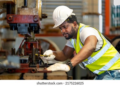 African American Industrial Worker Is Using Hydraulic Power Press Machine To Make Metal And Steel Part While Working Inside The Metal Sheet Galvanized Roof Factory For Safety Industry