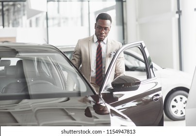 An African American Inspects The Car At The Car Dealership. Good Bargain