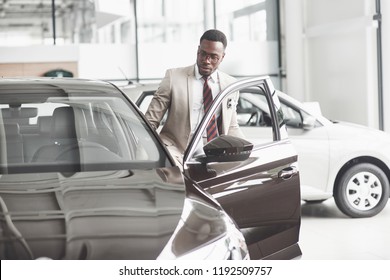 An African American Inspects The Car At The Car Dealership. Good Bargain