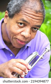 African American Jazz Musician With His Flugelhorn Outside.