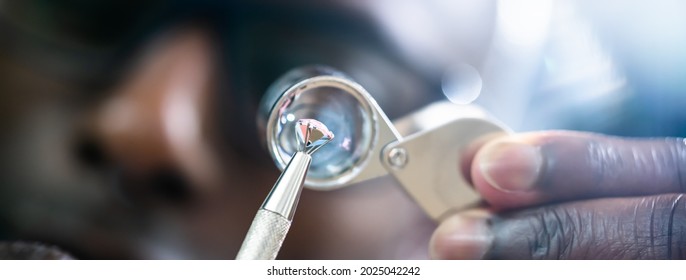 African American Jeweler Holding Diamond And Using Loupe Glass - Powered by Shutterstock