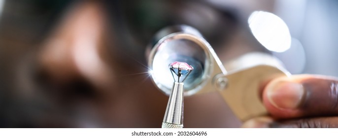 African American Jeweler Holding Diamond And Using Loupe Glass - Powered by Shutterstock