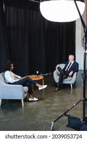 African American Journalist Talking With Businessman During Talk Show