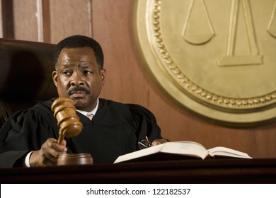 African American Judge Holding Mallet In Courtroom