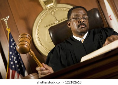 African American Judge Holding Mallet In Courtroom