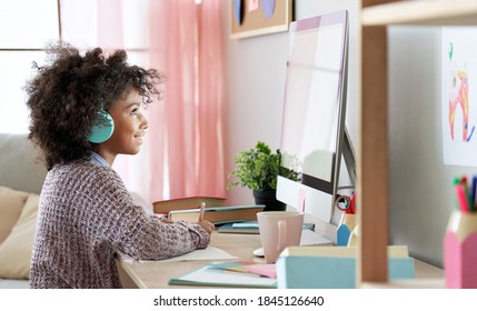 African american kid girl online learning on computer at home. Cute mixed race child wearing headphones distance studying online class looking at pc screen. Virtual remote school for children concept. - Powered by Shutterstock