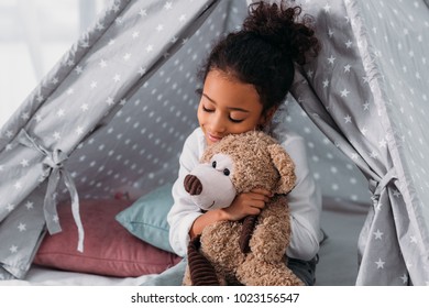 kid hugging teddy bear