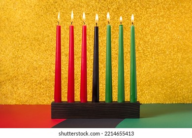 African American Kwanzaa holiday concept with traditional lit candles on symbolic background - Powered by Shutterstock