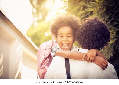 African American Little Girl In Fathers Hug. Looking At Camera. Close Up.