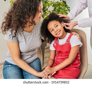 African American Little Girl With Her Parent While Installing Hearing Aid By Her Audiologist. Hearing Treatment For A Child