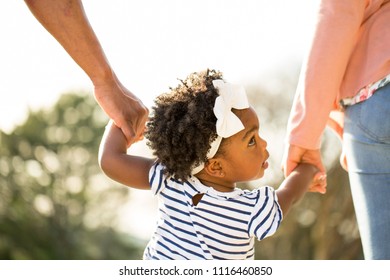 African American Little Girl Holding Hands With Her Parents.